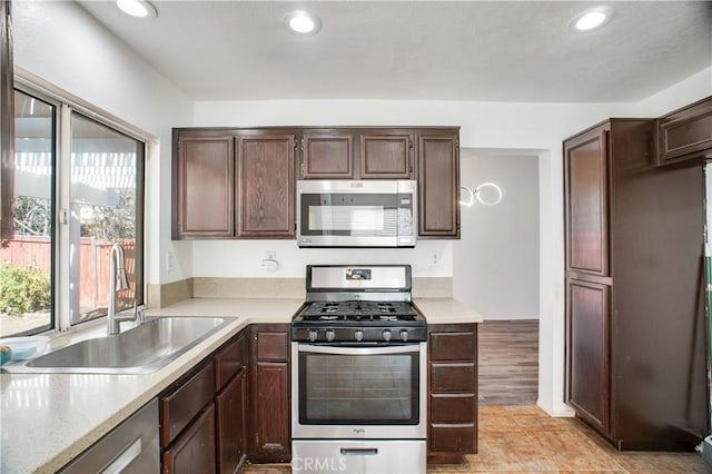 kitchen with stainless steel appliances, recessed lighting, light countertops, and a sink