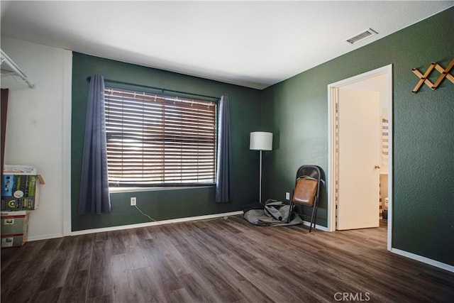 interior space with dark wood-style floors, baseboards, and visible vents