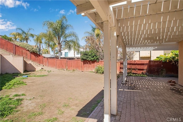 view of yard featuring a patio area, a fenced backyard, and a pergola