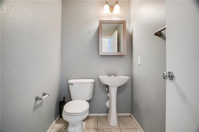 bathroom featuring tile patterned flooring, toilet, and baseboards