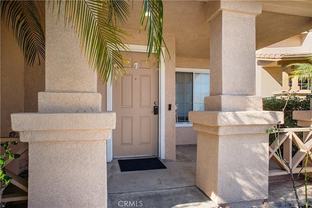 entrance to property featuring stucco siding