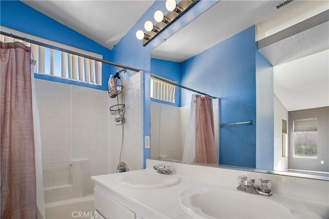 full bathroom with a healthy amount of sunlight, a sink, and shower / bathtub combination with curtain