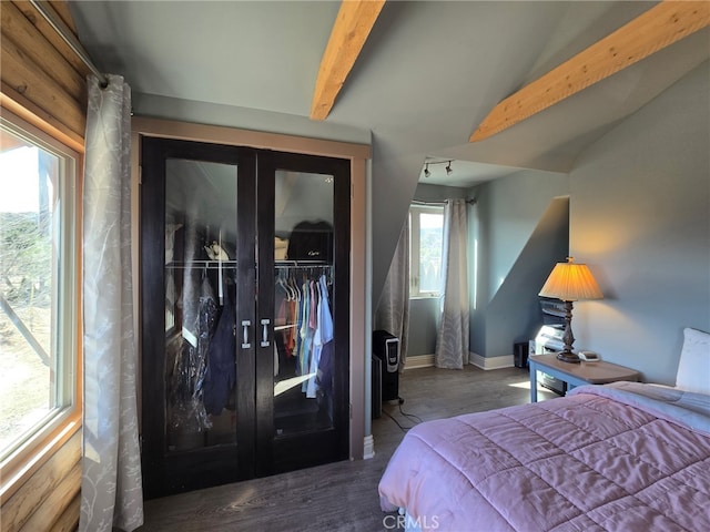 bedroom with french doors, dark hardwood / wood-style floors, vaulted ceiling with beams, and a closet