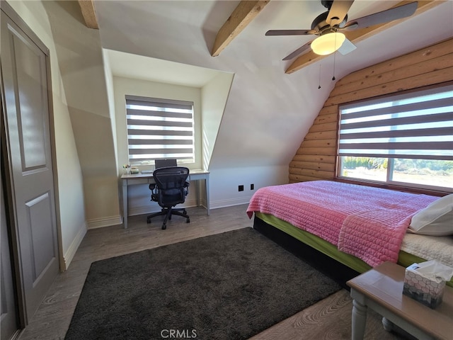 bedroom featuring wood-type flooring and vaulted ceiling with beams