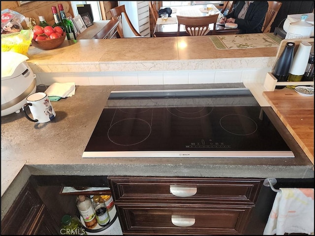 room details with dark brown cabinets and black electric stovetop