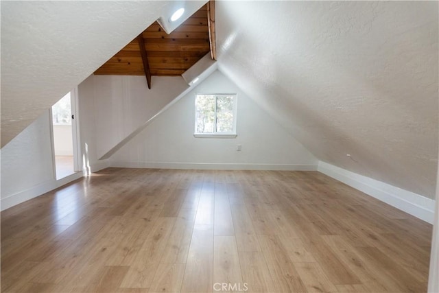 bonus room featuring lofted ceiling and light hardwood / wood-style flooring