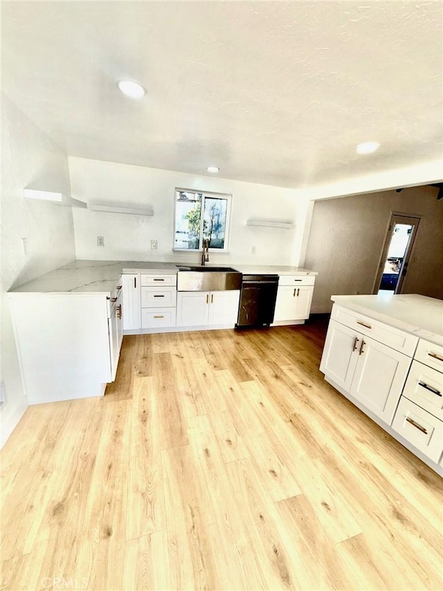 kitchen featuring dishwasher, sink, white cabinets, and light hardwood / wood-style floors