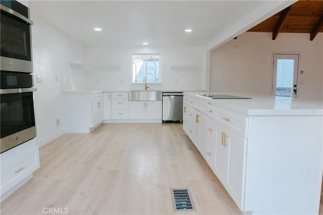 kitchen with white cabinetry, dishwasher, sink, and light wood-type flooring