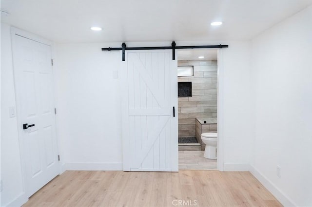 bathroom with a tile shower, hardwood / wood-style floors, and toilet