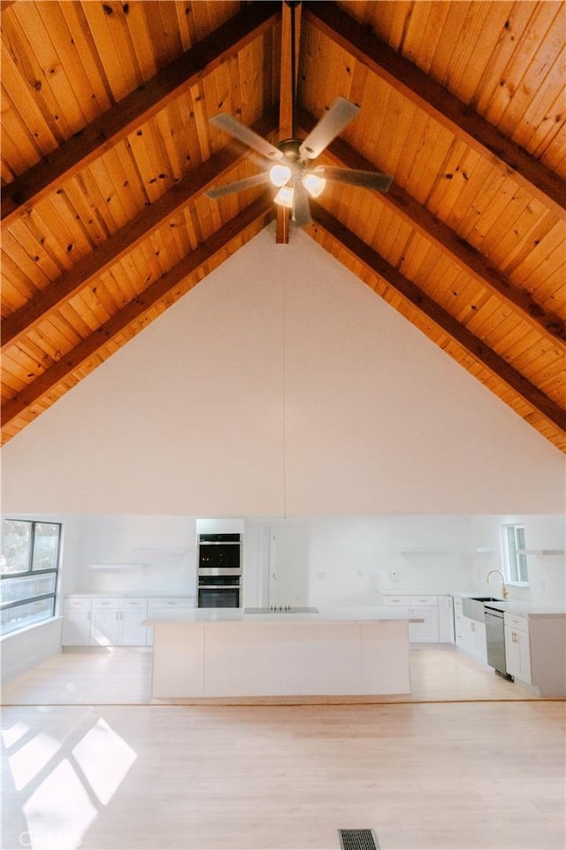 interior space featuring beamed ceiling, sink, wood ceiling, and light wood-type flooring