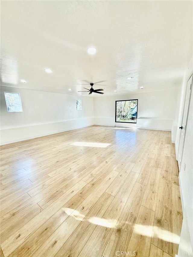 unfurnished living room with ceiling fan, a healthy amount of sunlight, and light hardwood / wood-style floors