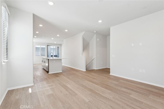 2718 Crozier Ct, Pomona, CA 91767 - unfurnished living room with light wood-type flooring, recessed lighting, a sink, and baseboards