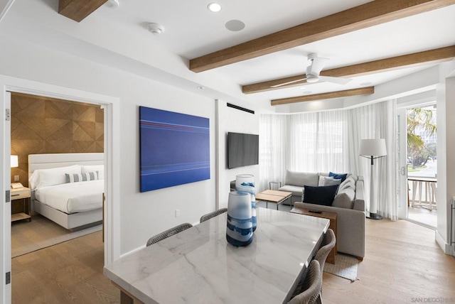 dining space featuring beam ceiling, light hardwood / wood-style floors, and ceiling fan