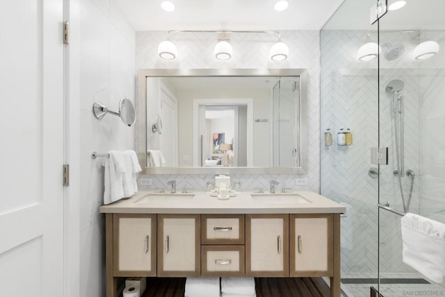 bathroom with tasteful backsplash, vanity, a shower with door, and tile walls