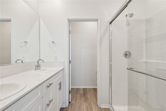 2720 Crozier Ct, Pomona, CA 91767 - bathroom with a shower stall, wood finished floors, double vanity, and baseboards