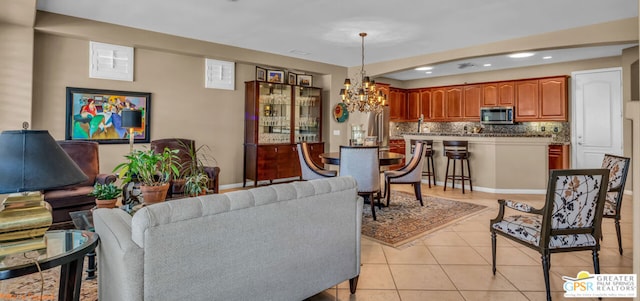 living room with light tile patterned floors and an inviting chandelier