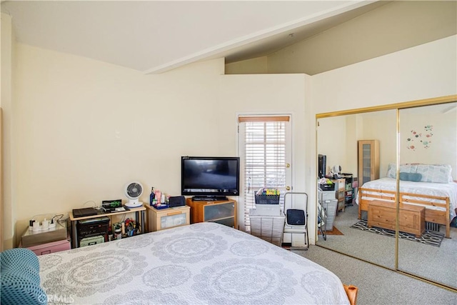 bedroom featuring vaulted ceiling, a closet, and carpet