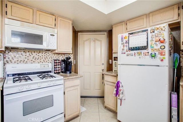 kitchen with light tile patterned flooring, light brown cabinetry, backsplash, and white appliances