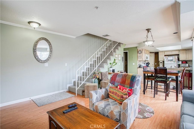 living room featuring ornamental molding and light hardwood / wood-style floors