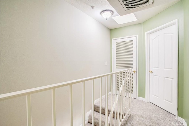 hall featuring carpet flooring and a skylight