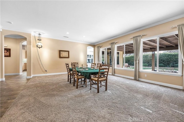 carpeted dining space with ornamental molding