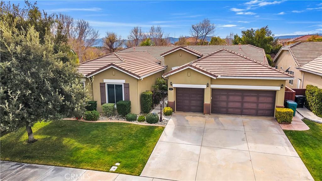 single story home with a garage and a front lawn