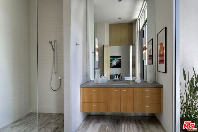 bathroom with vanity, hardwood / wood-style floors, and a tile shower