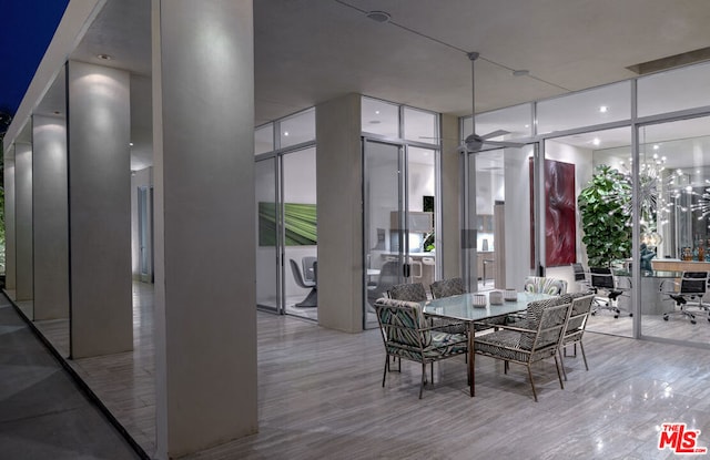 dining room with floor to ceiling windows, light hardwood / wood-style flooring, and plenty of natural light