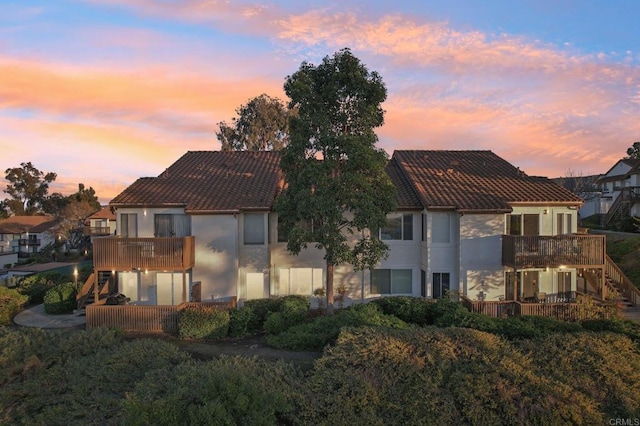 back house at dusk with a balcony