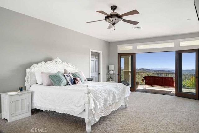 bedroom with a mountain view, carpet floors, access to outside, and ceiling fan