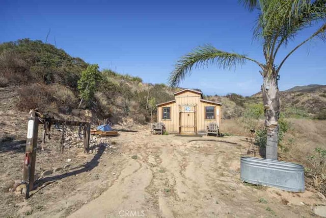 view of yard with a mountain view and a storage shed