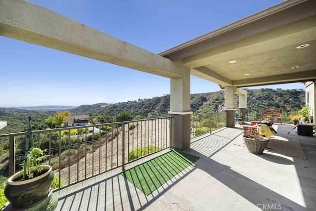 view of patio / terrace with a mountain view and a balcony