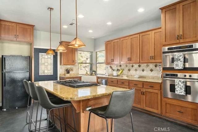 kitchen featuring light stone counters, tasteful backsplash, hanging light fixtures, a kitchen island, and black appliances