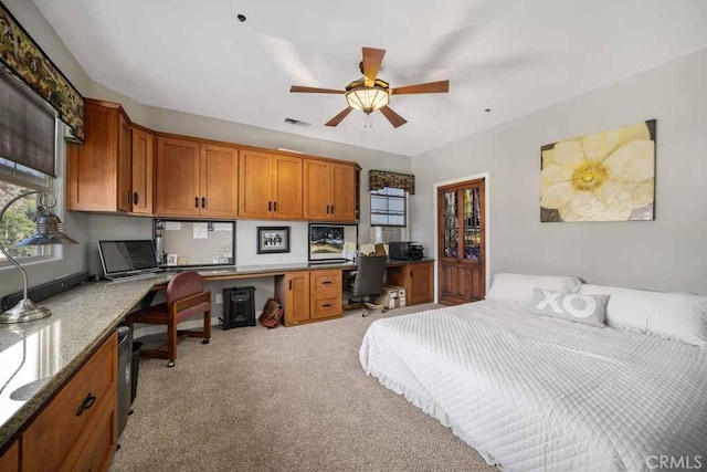 carpeted bedroom with built in desk