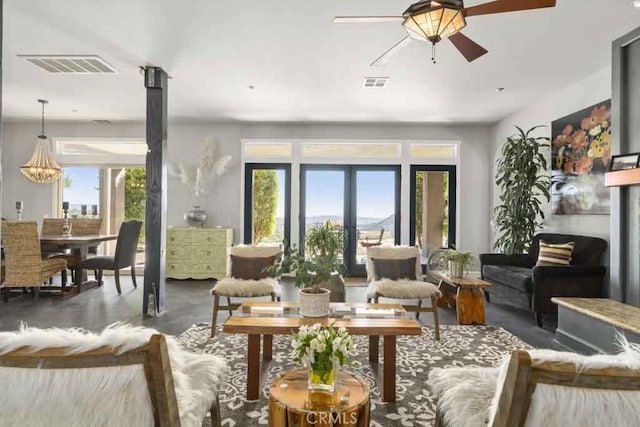 living room with ceiling fan with notable chandelier and french doors