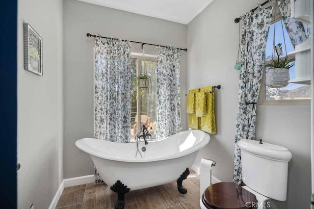 bathroom featuring hardwood / wood-style flooring, toilet, and a bathing tub