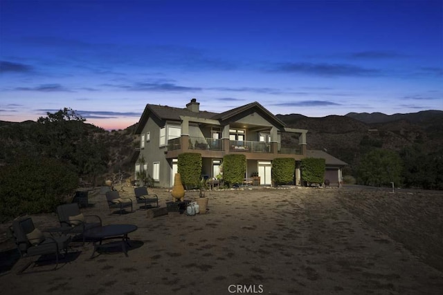 view of front of property with a balcony, a garage, and a mountain view