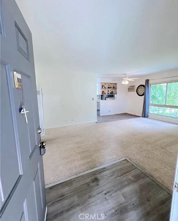 interior space featuring ceiling fan, carpet, and wood finished floors