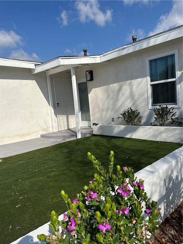 view of exterior entry with a lawn