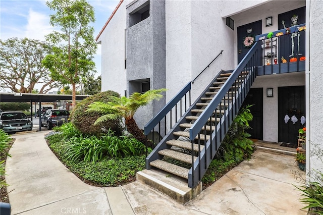 exterior space featuring stucco siding and stairs