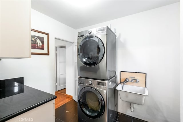 laundry area with stacked washing maching and dryer and sink