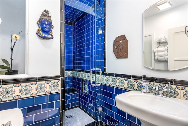 bathroom with tile walls, sink, and tiled shower