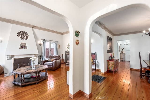 hall with an inviting chandelier, hardwood / wood-style floors, and ornamental molding