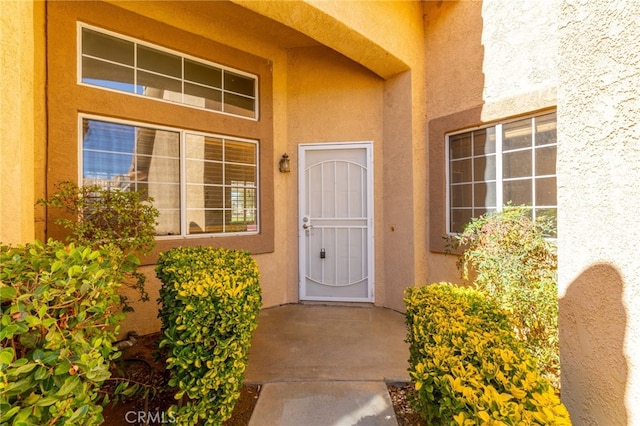 view of exterior entry featuring stucco siding