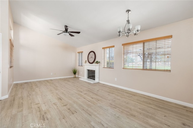 573 La Costa Dr, Banning, CA 92220 - unfurnished living room with baseboards, a glass covered fireplace, wood finished floors, and ceiling fan with notable chandelier