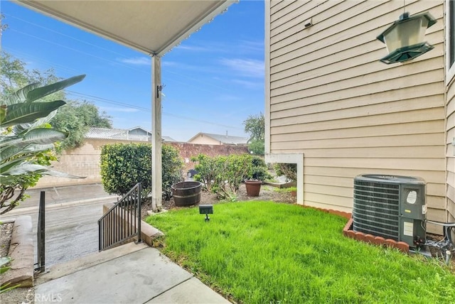 view of yard featuring central AC unit and fence