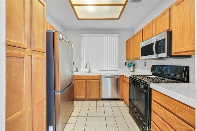 4900 N Grand Ave Unit 325, Covina, CA 91724 - kitchen featuring appliances with stainless steel finishes, light tile patterned flooring, light countertops, and a sink