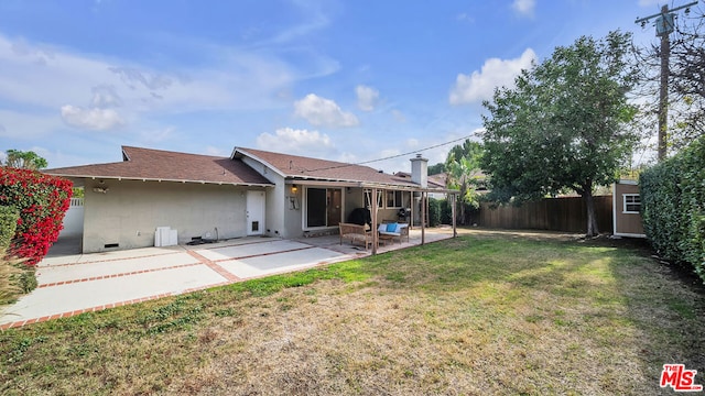 back of house featuring a yard, a storage unit, and a patio