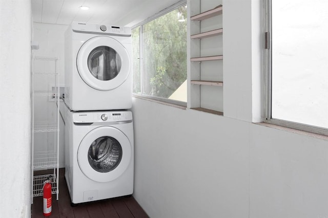 washroom featuring stacked washing maching and dryer and dark hardwood / wood-style flooring