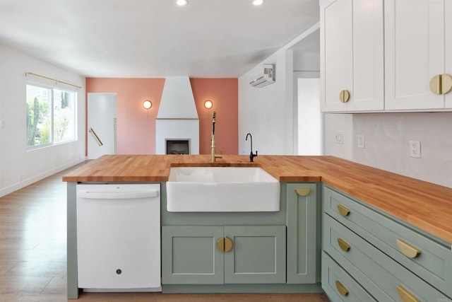 kitchen with sink, white cabinetry, green cabinetry, wooden counters, and dishwasher